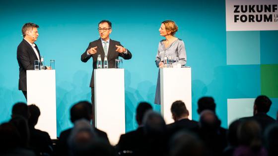 Bundesminister Özdemir und Bundesminister Habeck stehen mit der Moderatorin auf der Bühne