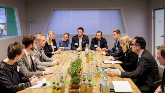 Bundesminister Özdemir sitzt mit einer Gruppe von Junglandwirten im Gespäch um einen Tisch