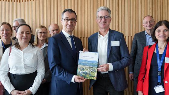 Bundesminister Özdemir und Prof. Dr. Feindt, Vorsitzender Wissenschaftlicher Beirat für Biodiversität und Genetische Ressourcen des Bundesministeriums halten die Broschüre der Strategie in die Kamera