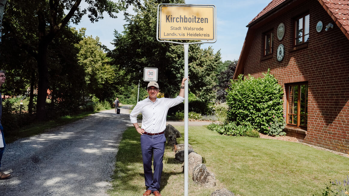 Bundesminister Özdemir am Ortseingangsschild von Kirchboitzen, Stadt Walsrode, Landkreis Heidekreis