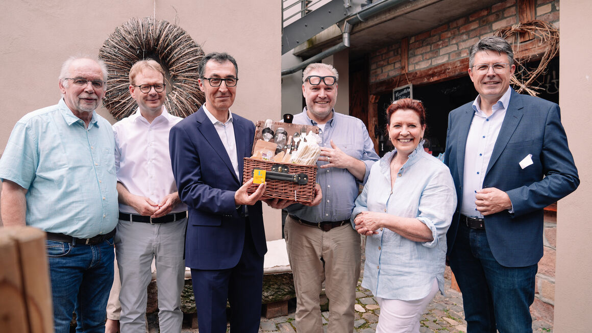 Gruppenfoto, Bundesminister Cem Özdemir hält einen Picknickkoffer in den Händen