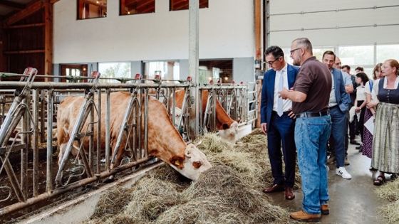 Bundesminister Cem Özdemir besichtigt den Kuhstall mit fressenden Kühen