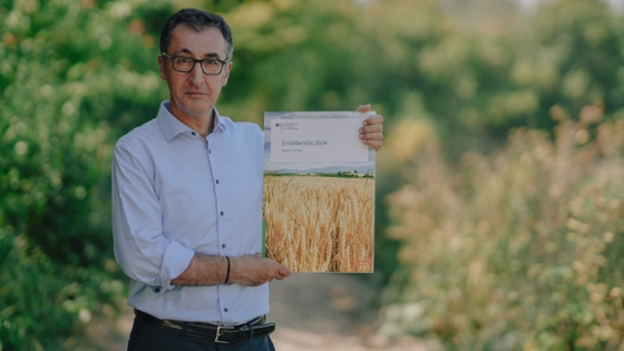 Bundesminister Özdemir hält die Broschüre des Ernteberichtes in die Kamera