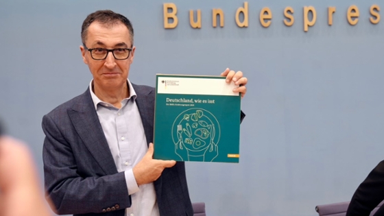 Bundesminister Cem Özdemir hält den Ernährungsreport 2024 in die Kamera