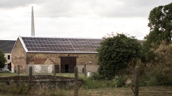 Blick auf ein Stallgebäude mit einer Solaranlage