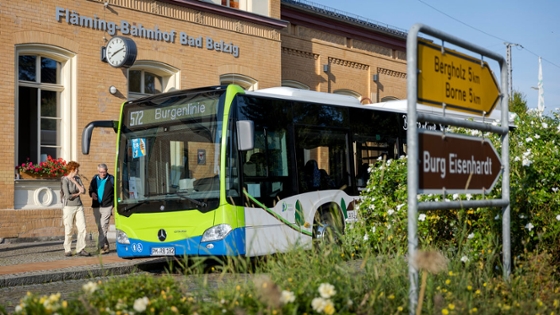 Vor einem Bahnhofsgebäude steht ein Linienbus