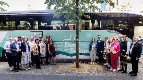 Bundesminister Cem Özdemir und Jurymitgleider des Wettbewerb vor einem Bus