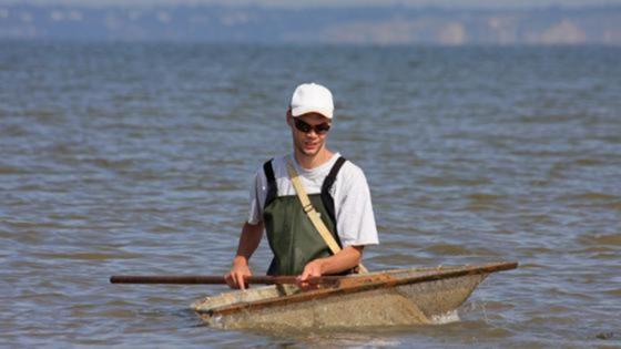 ein Mann in der See mit einem Fangnetz