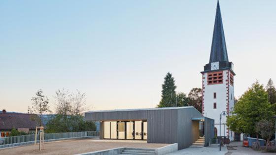 Gemeindehaus vor einer Kirche