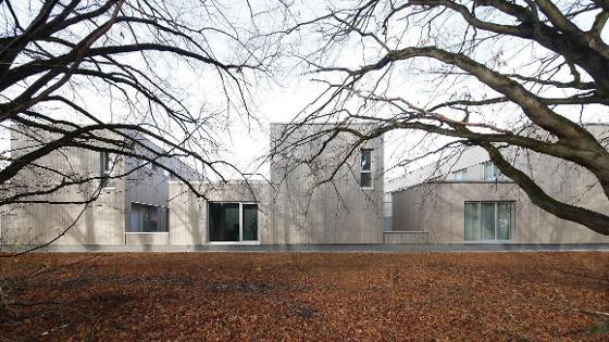 mehrere Gebäude aus hellem Holz mit großen Fenstern