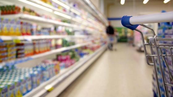 Einkaufswagen und Blick in einen Supermarktgang