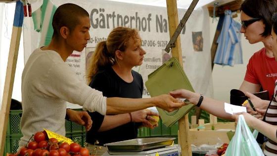 Gespräch und Verkauf am Marktstand