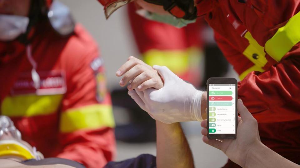 Die Rescue App wird mit einem Handy während eines Notfalleinsatzes genutzt.