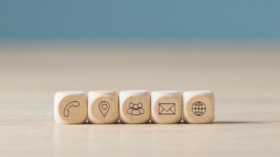 Five dice with various communication symbols on them