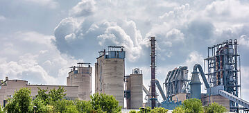 Fabrikanlage mit Schornsteinen stößt Rauch aus