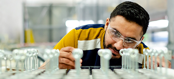 Man in safety glasses looking at work area.