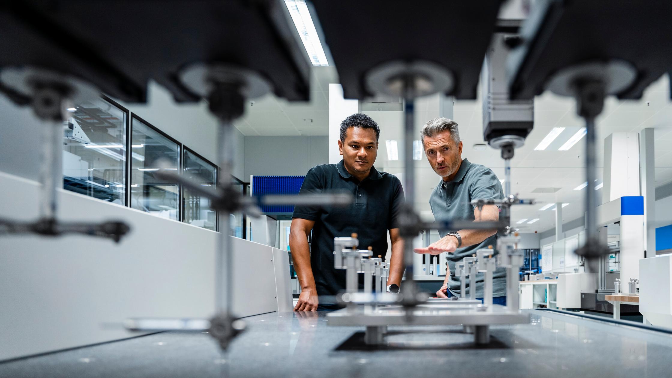 Quality - Engineers discussing over machinery at factory