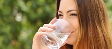 Frau trinkt Wasser aus einem Glas