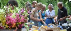 Menschen stehen bei einem Sommerfest an einem Buffet