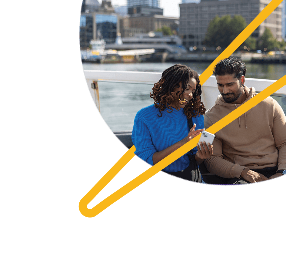 A man and a woman looking at a phone while riding on a ferry.