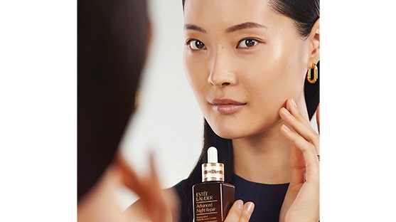 photo of woman applying estee lauder advanced night repair serum for sleep deprived skin