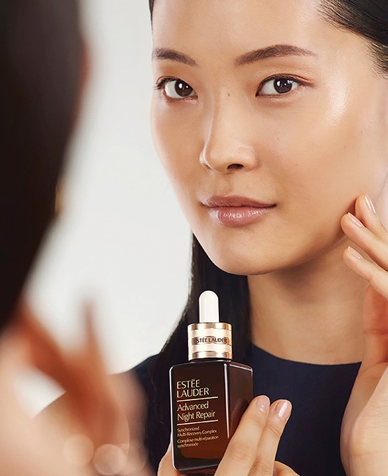 photo of woman applying estee lauder advanced night repair serum for sleep deprived skin