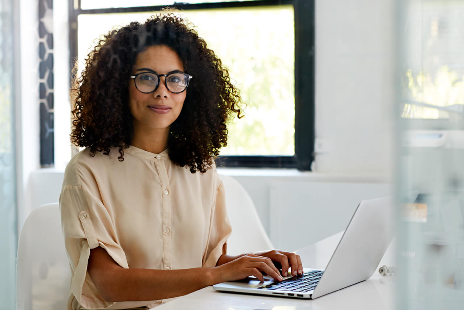 mujer mirando al frente escribiendo en un computador