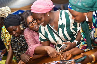 This photo shows attendees of a PhotoVoice exhibition on cleft lip and palate in Lagos , Nigeria, looking through a book of photos.