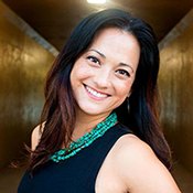 This photo shows Dr. Lisa Labita Woodson smiling and wearing a dark colored shirt and a turquoise necklace