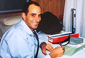 Dr. Thomas Gaziano seated in exam room taking notes