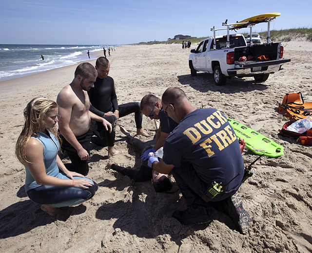 Surf Rescue lifeguards and EMTs train by doing a simulation of a swimmer in trouble before the kickoff of the tourist season in Duck, NC. Duck, NC is now on FirstNet and is relying on its connectivity and reliability for first responders doing everyday work such as guarding beaches, as well as for events such as hurricanes.