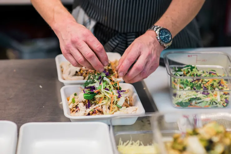 A restaurant staffer prepares food delivery orders min