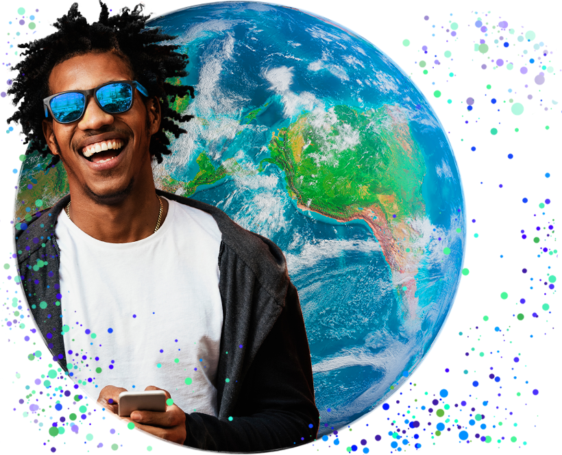 Grinning dark-haired, dark-skinned person in a white T-shirt and denim jacket holding a cell phone, a globe in the background