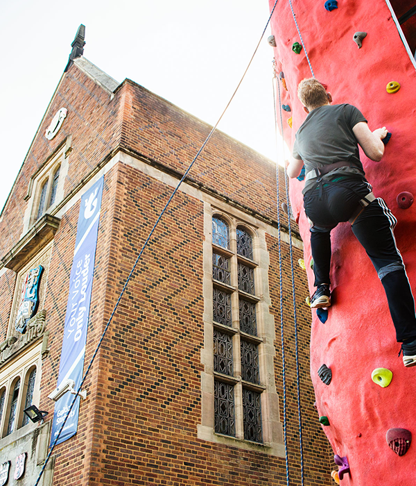 a student rock climbing outside of the guild