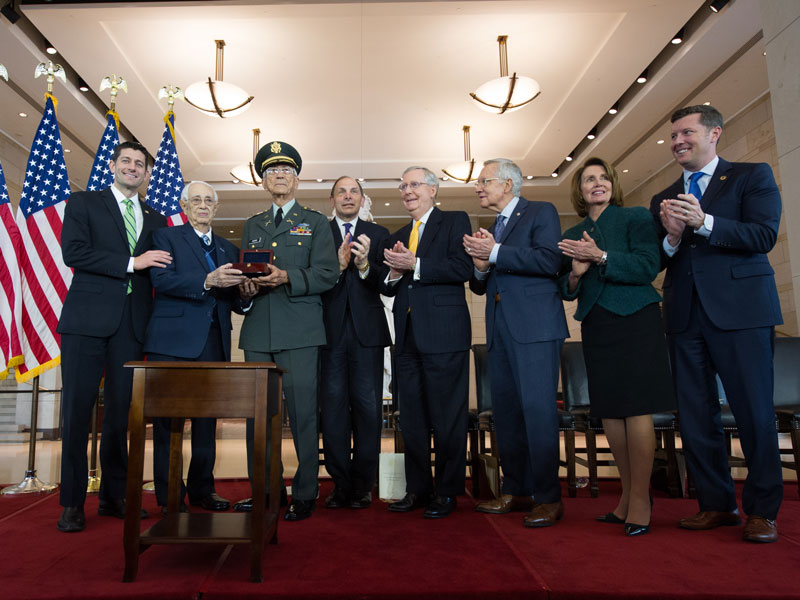 Sergeant Major José E. Colón and Colonel Manuel F. Siverio Sr. holding a medal together