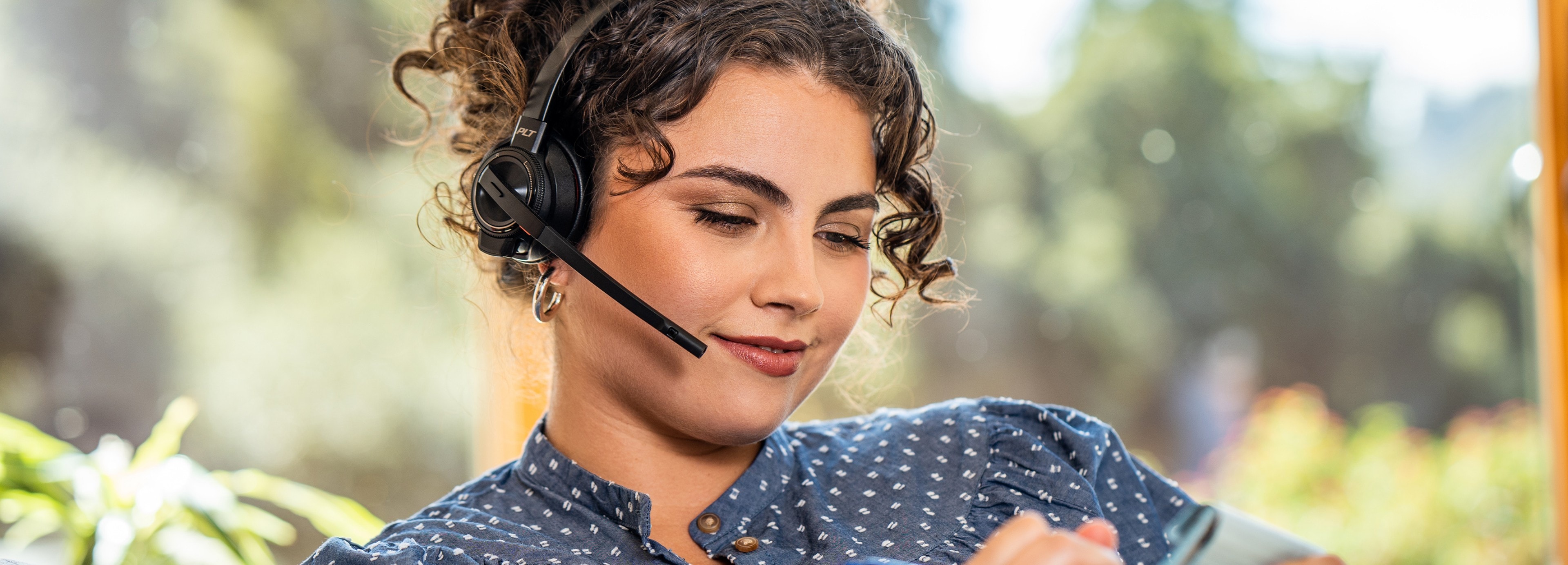 A woman wearing a Poly headset