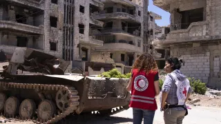 An ICRC weapons contamination specialist talks to a Syrian Arab Red Crescent staff member during an explosive ordnance disposal training session. Ammar Saboh/ICRC