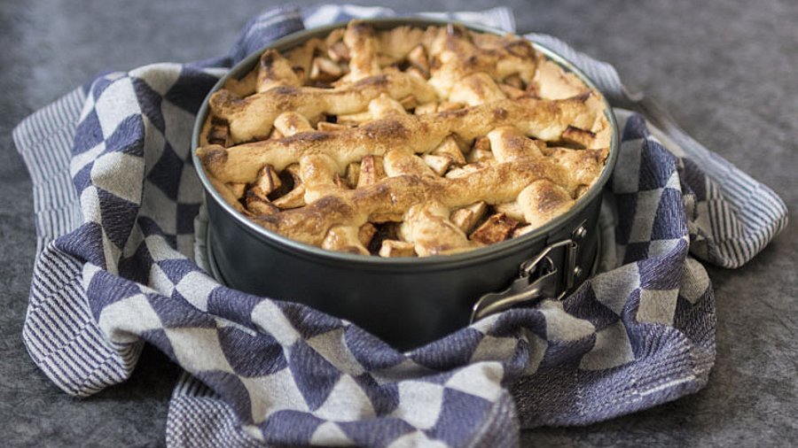 1 Apfelkuchen in der Backform präsentiert auf einem Küchenhandtuch