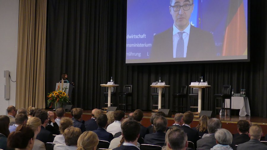 Blick auf das Publikum der Innovationstage 2022 mit der auf Leinwand übertragenen Videobotschaft vom Bundeslandwirtschaftsminister Cem Özdemir © BLE