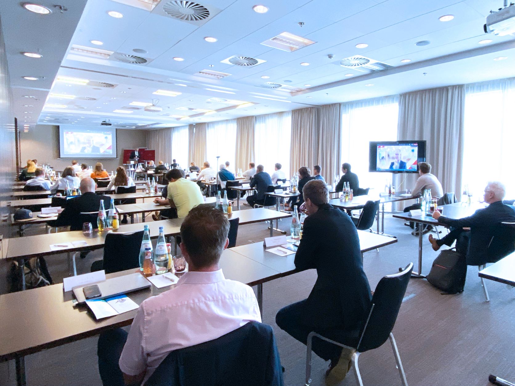 teilnehmende der Veranstaltung sitzen im Konferenzraum.