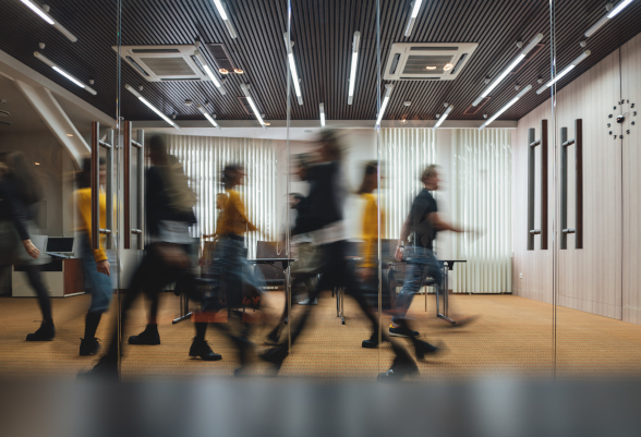 Männer und Frauen durchschreiten ein Büro.