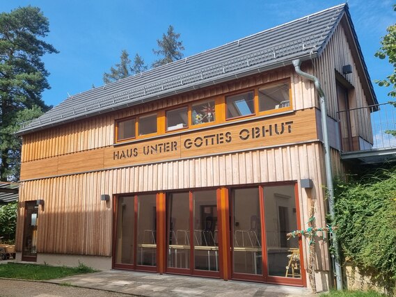 Sicht auf das neu gebaute Haus unter Gottes Obhut mit Holzverkleidung