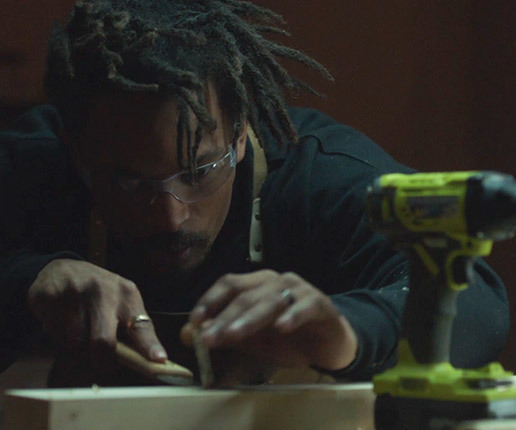 Woodworker wearing goggles while sanding a piece of wood