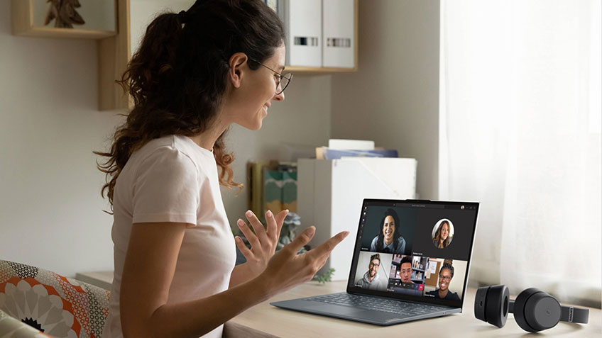 A woman in her house using a laptop for a virtual meeting