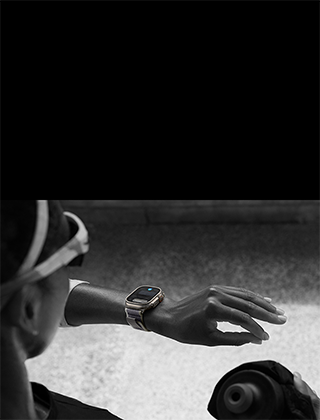 Jogger looking at Apple Watch Ultra 2 on left wrist, making double tap gesture with index finger and thumb of left hand