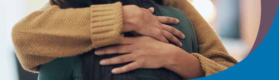 older woman hugging younger woman