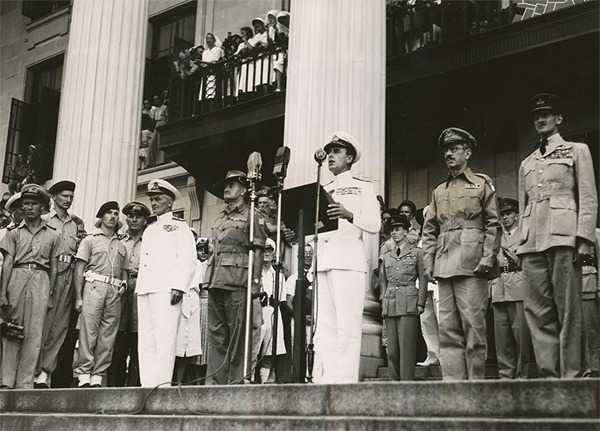 Admiral Lord Louis Mountbatten reads the order of the day about the Japanese surrender from the steps of the Municipal Building (12 Sept 1945).