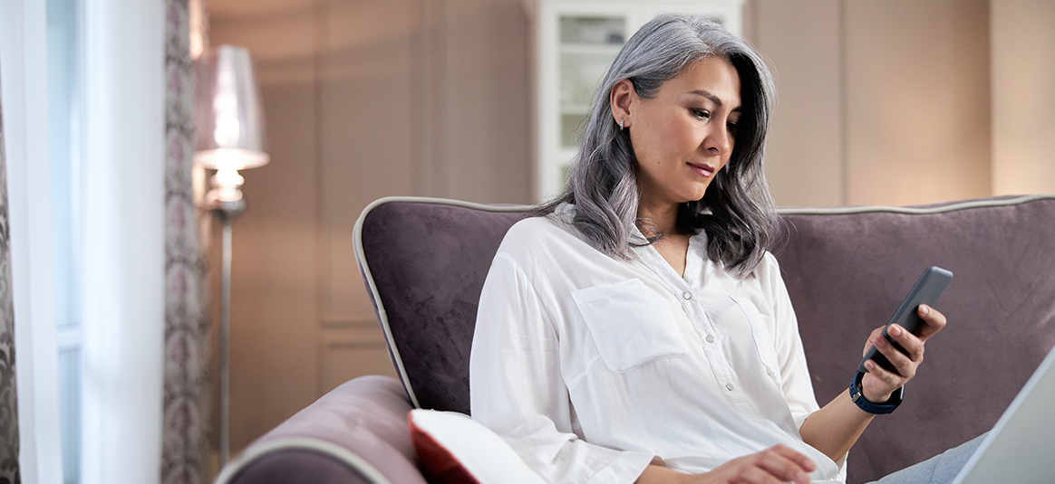 Photo of a woman looking at a scam on a mobile phone