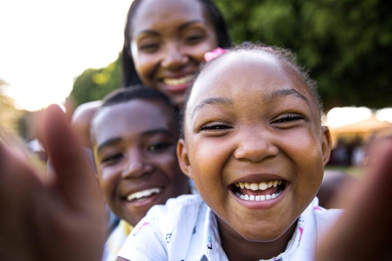 Two smiling kids with their mother