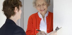 An elderly lady answering the door to a potential scammer trying to get personal information